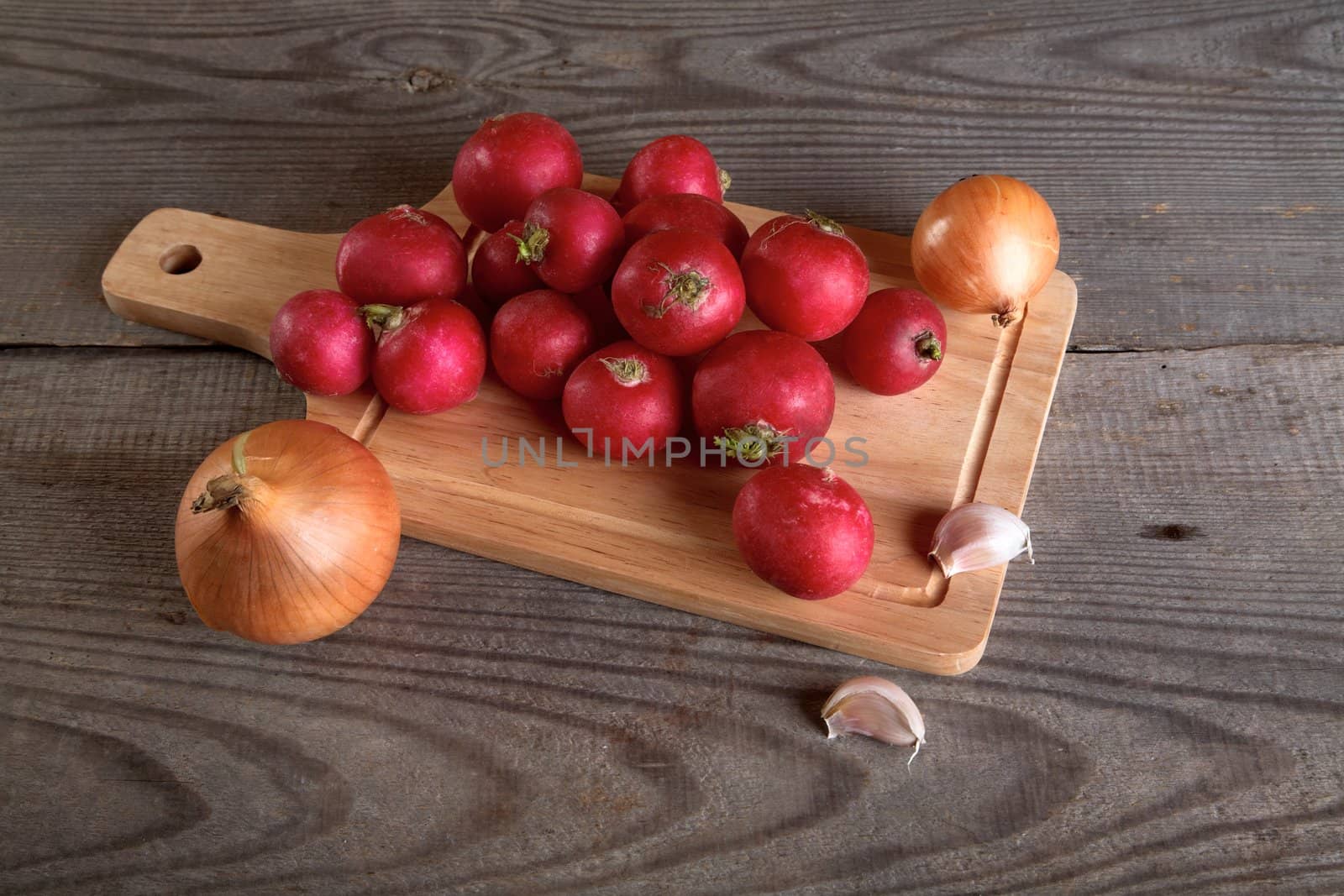 Onions garlic  garden radish on a table from unplaned boards