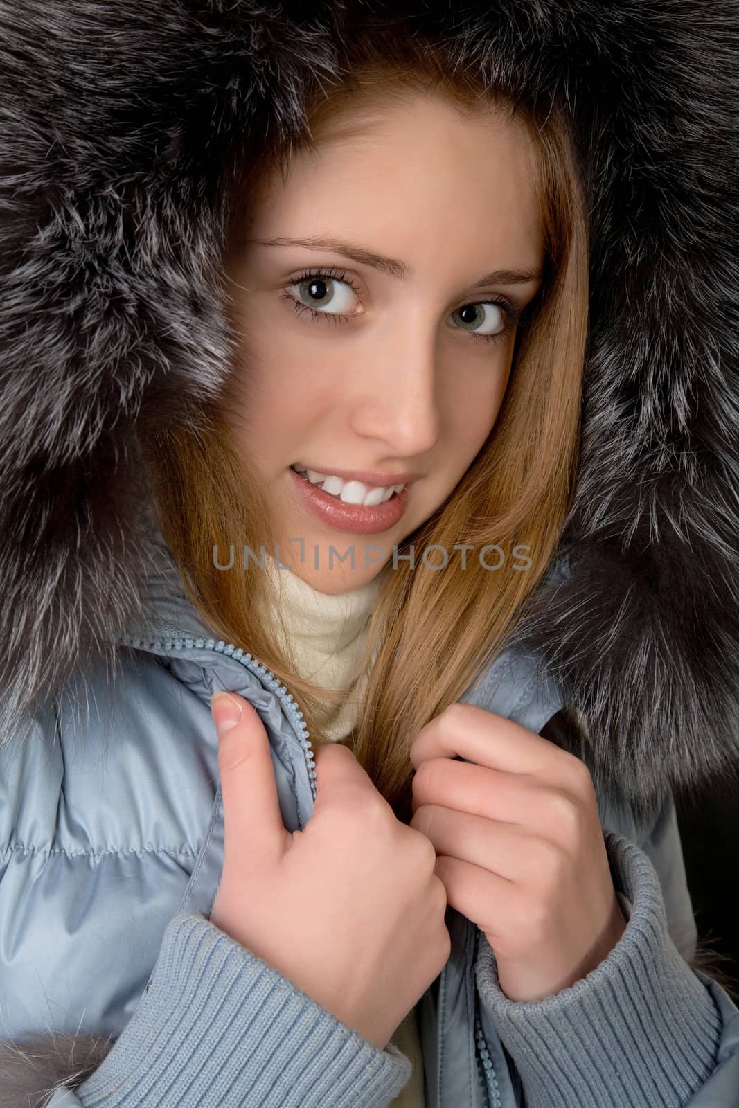 The girl in  warm jacket with a hood on  black background