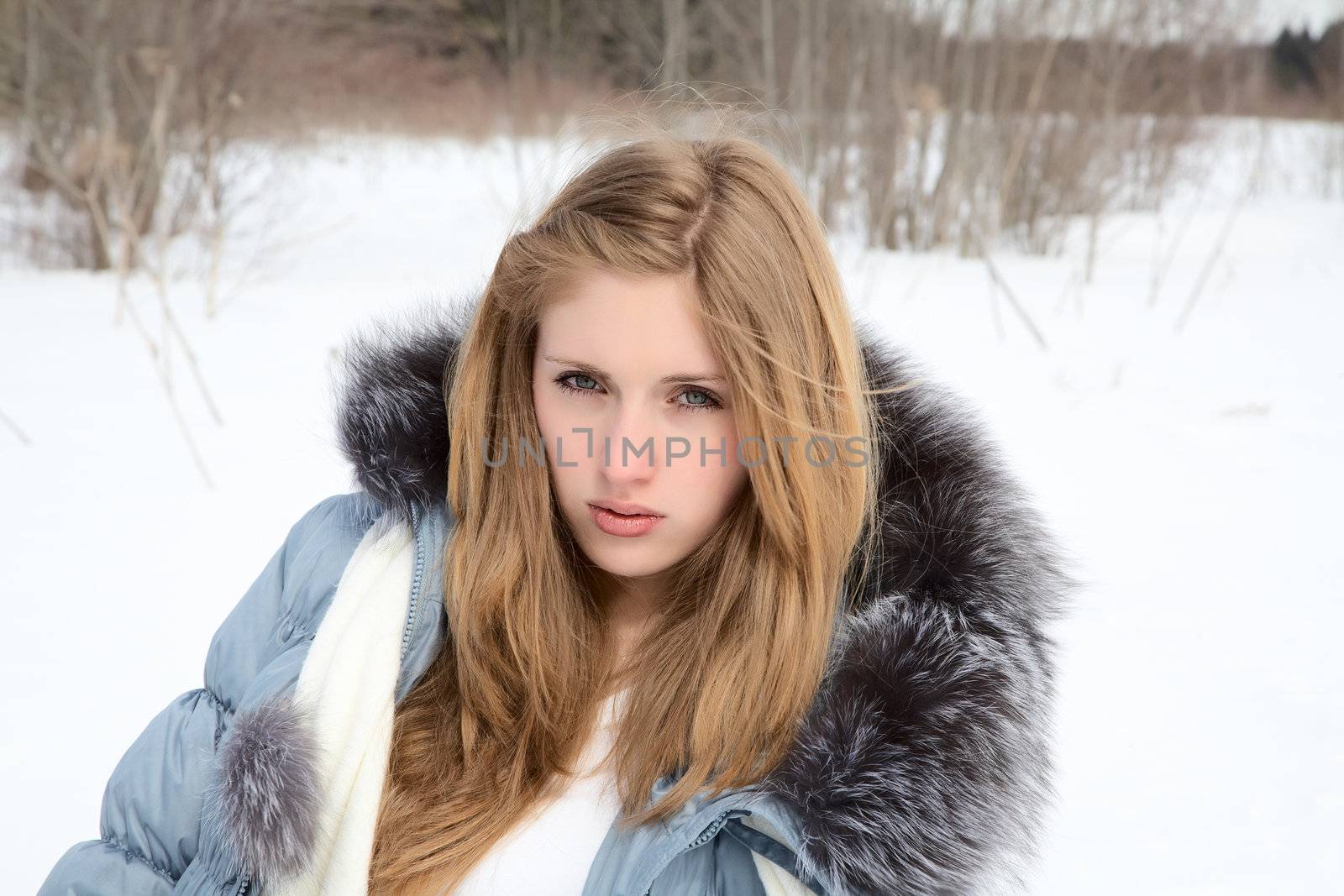 The beautiful girl against tree in the winter afternoon 