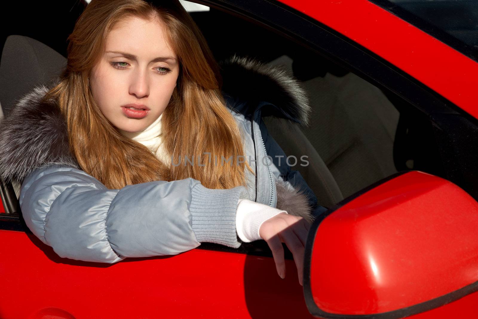 girl in the car looks a mirror  sunny day