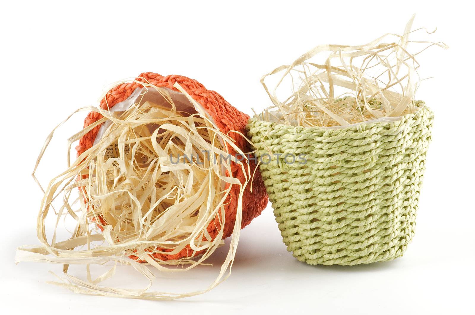 Green and red little wicker flower pots with straw isolated on white background