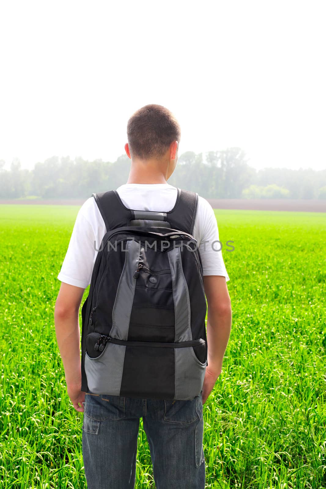 teenager with knapsack in the summer field