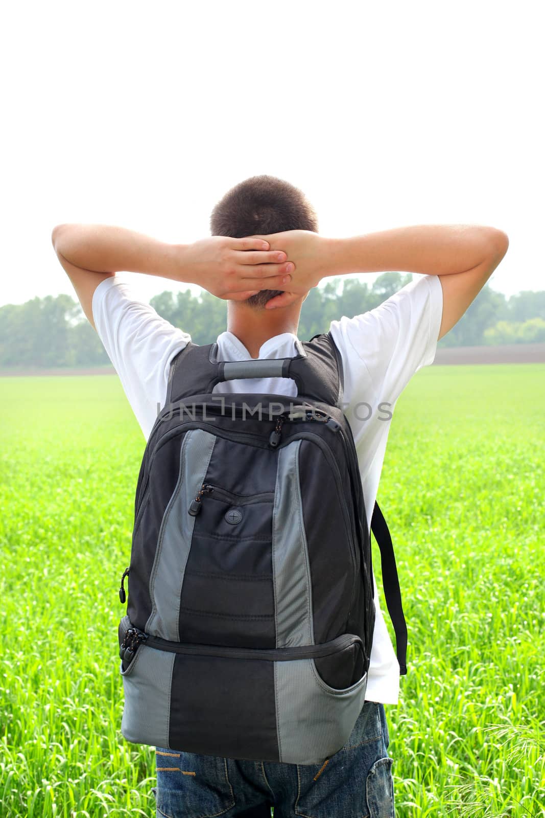 teenager with knapsack in the summer field