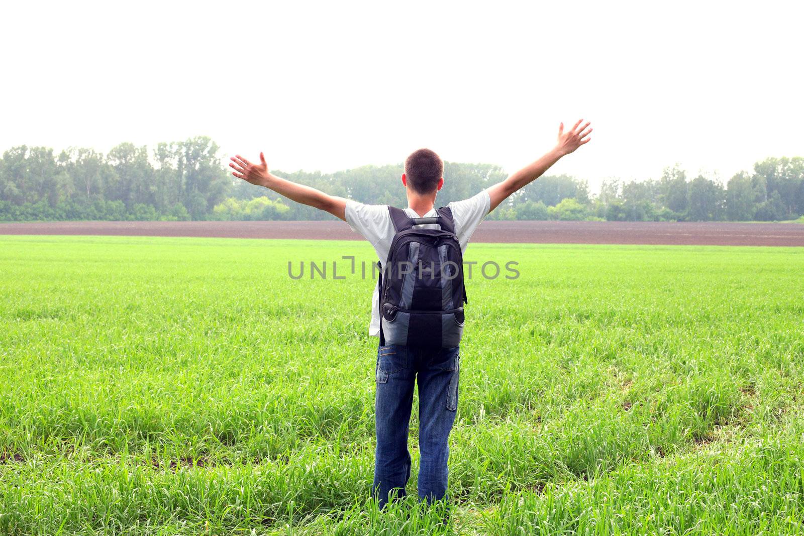 happy teenager with knapsack in the summer field