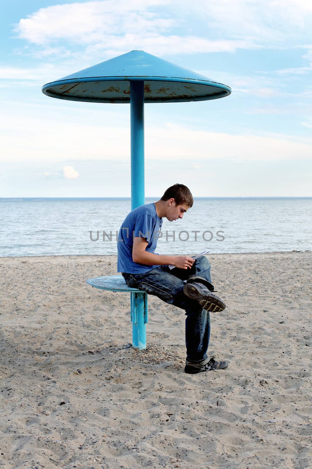 teenager reading letter on the empty beach