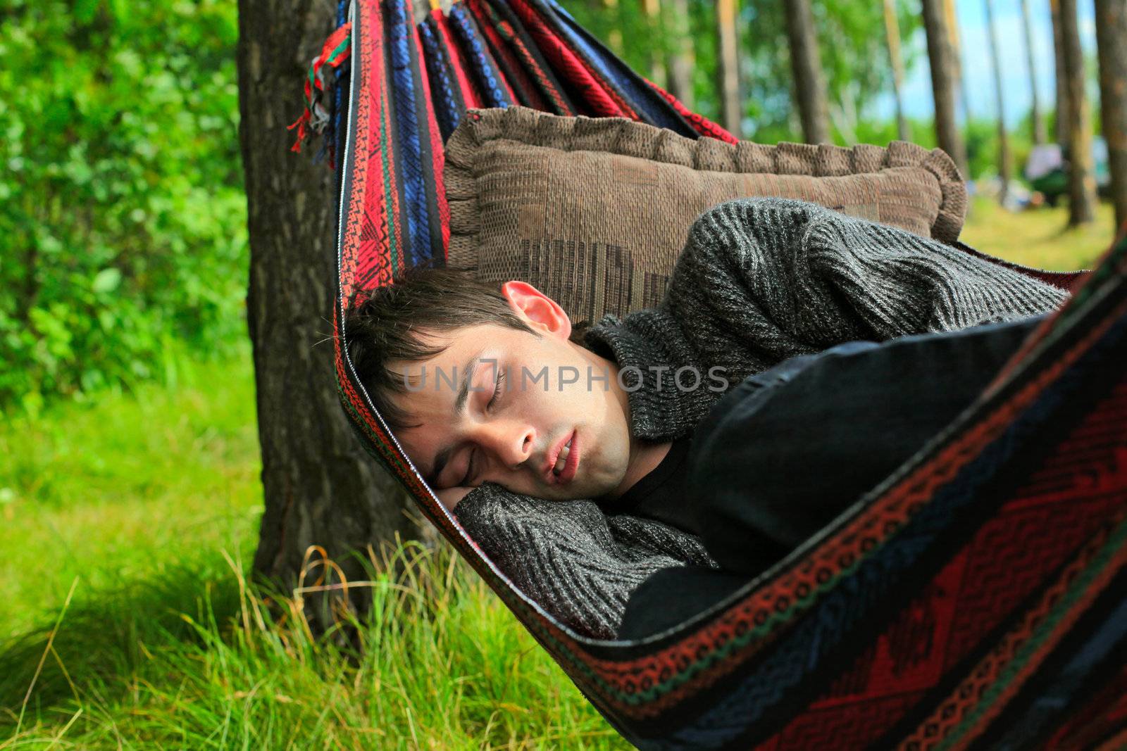 young man sleeping in the hammock on the nature