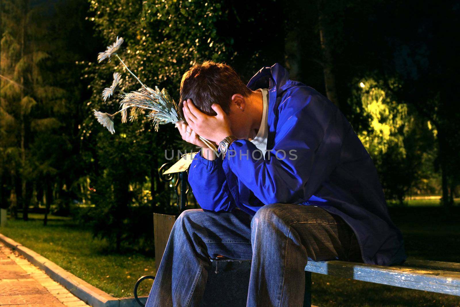 very sad teenager with a flowers in the night park get break an appointment