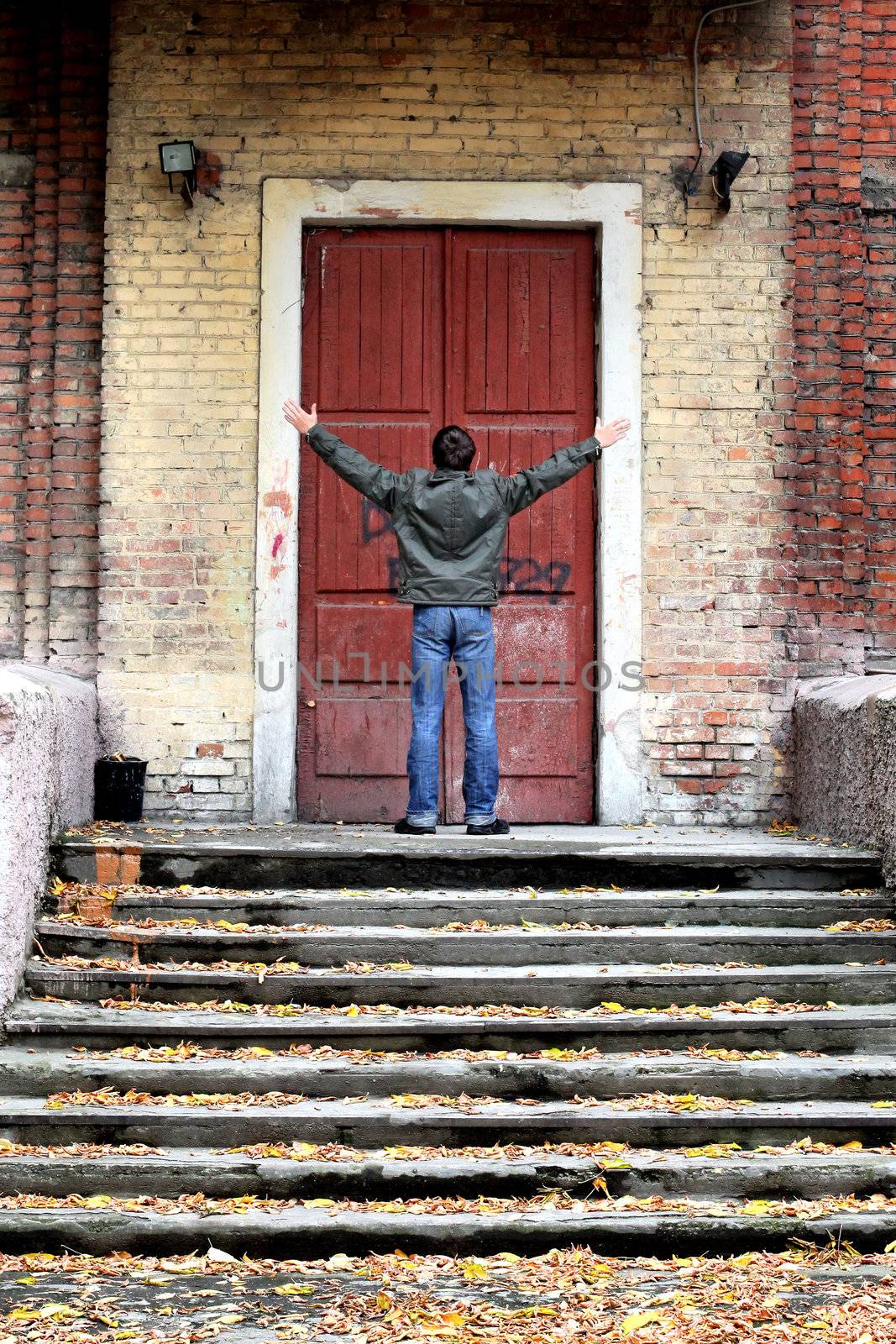 man spreading hands in front of the closed door