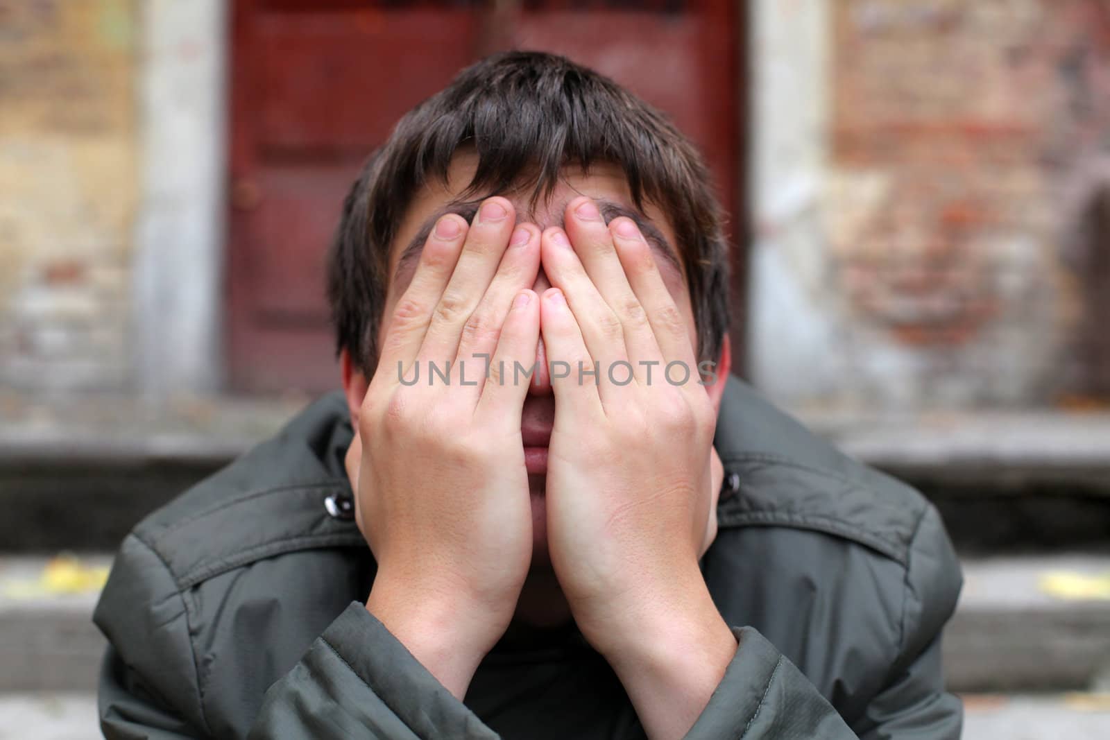 man with hidden face on the old house background