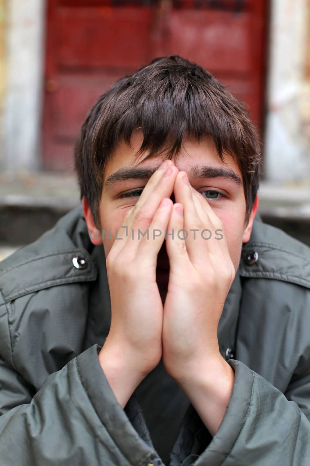 sad young man portrait on the old house background