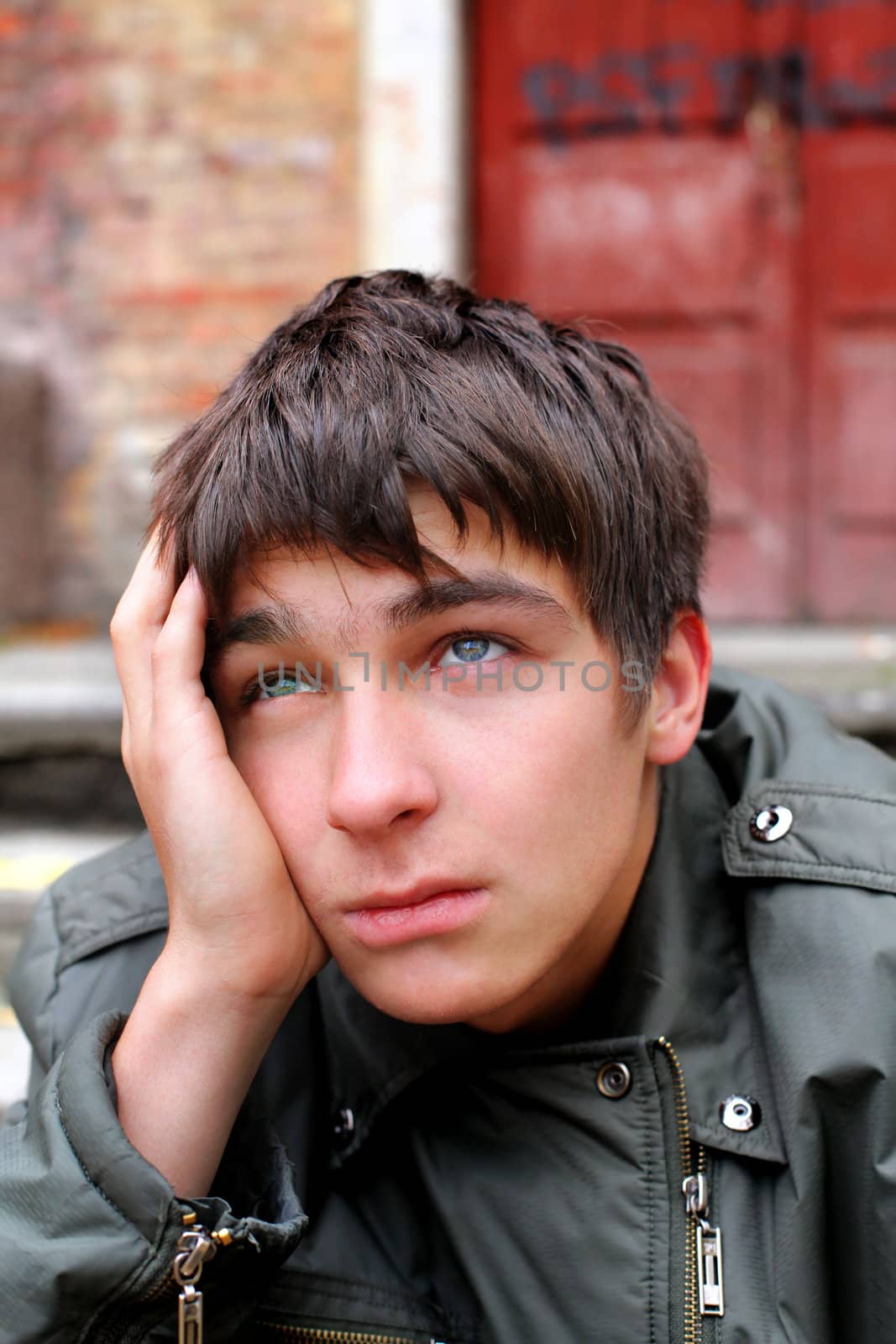 sad young man portrait on the old house background