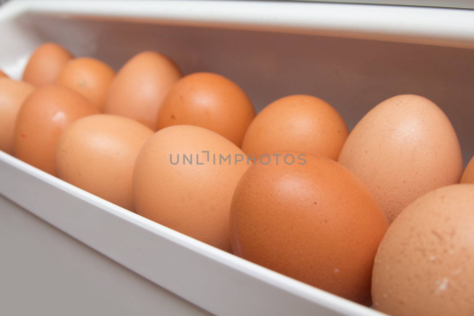 closeup of a pile of brown eggs in the fridge 