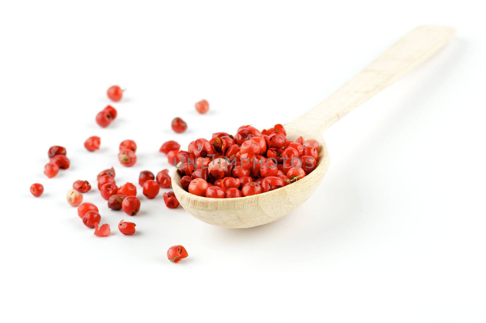 Red pepper in wooden spoon isolated on white background