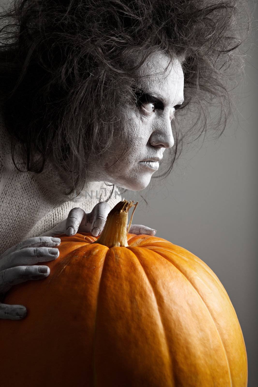 Woman with a bleached face and pumpkin. Halloween theme.