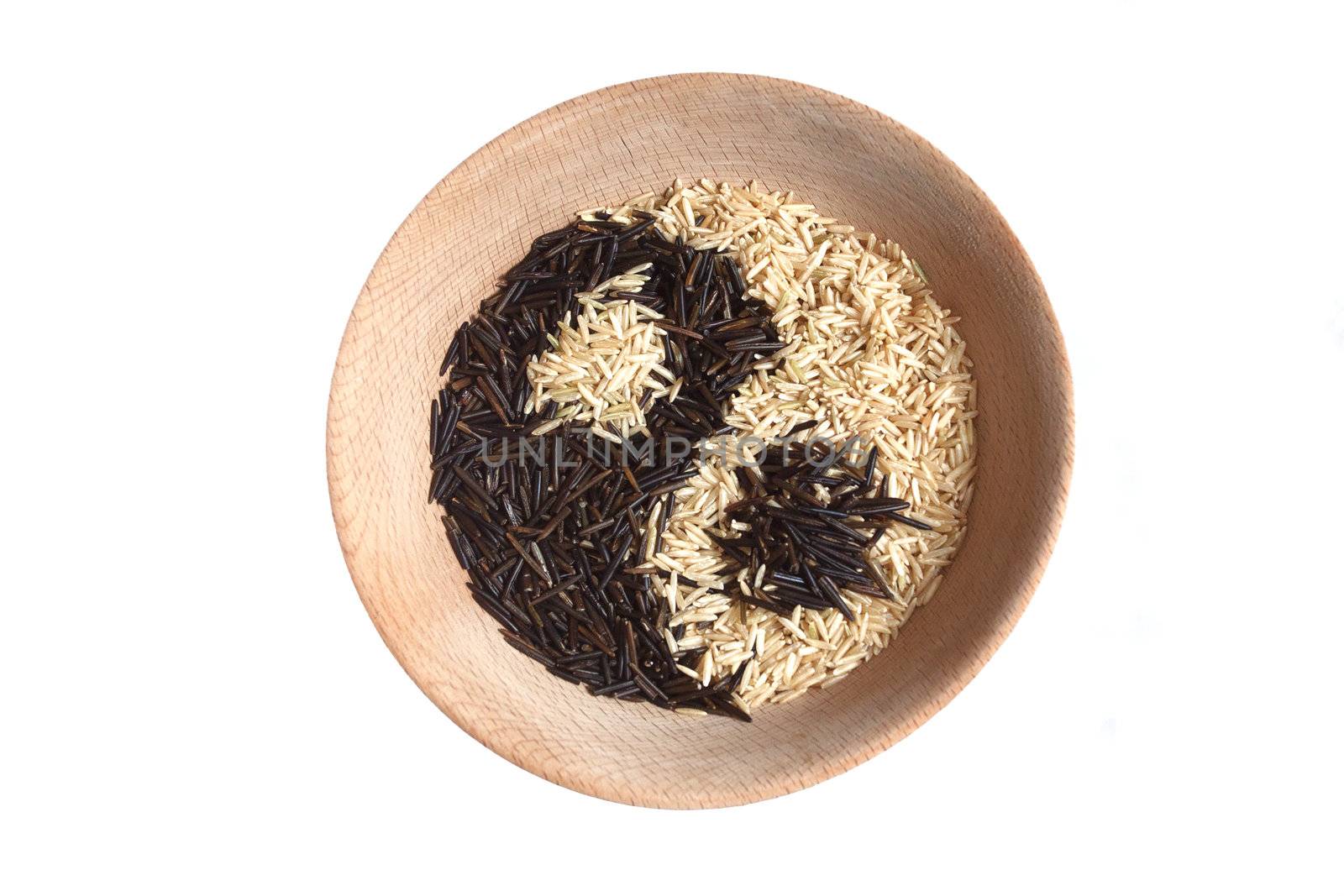 Yin and yang sign made of rice in wooden bowl.  by michalpecek