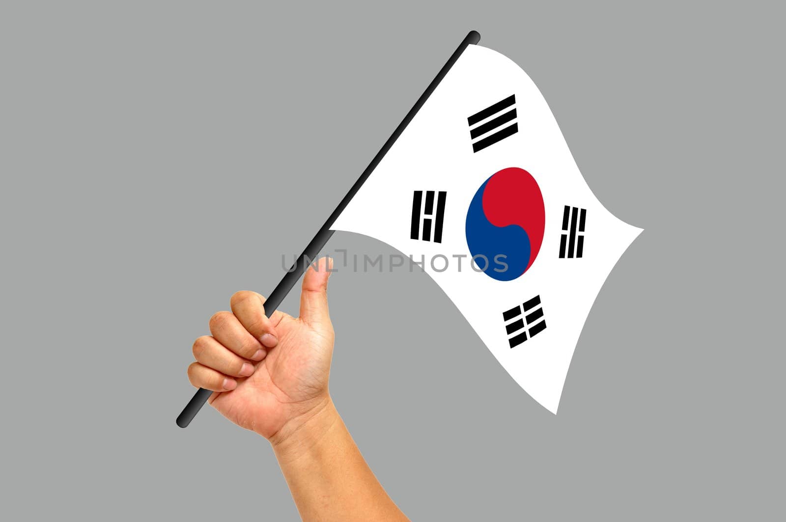 Hand holding South Korea flag isolated on white background