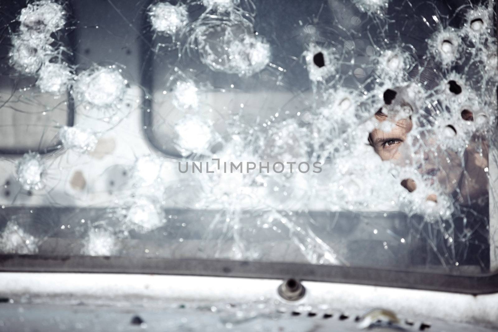 Man behind broken glass of the car
