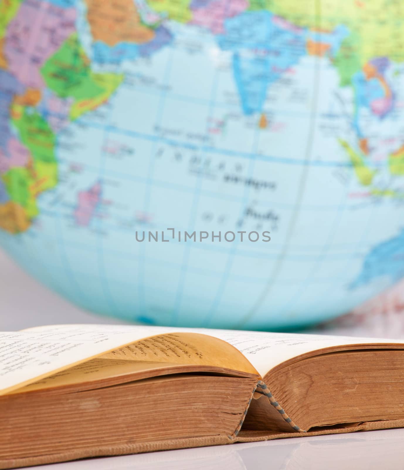 Open old book on globe background