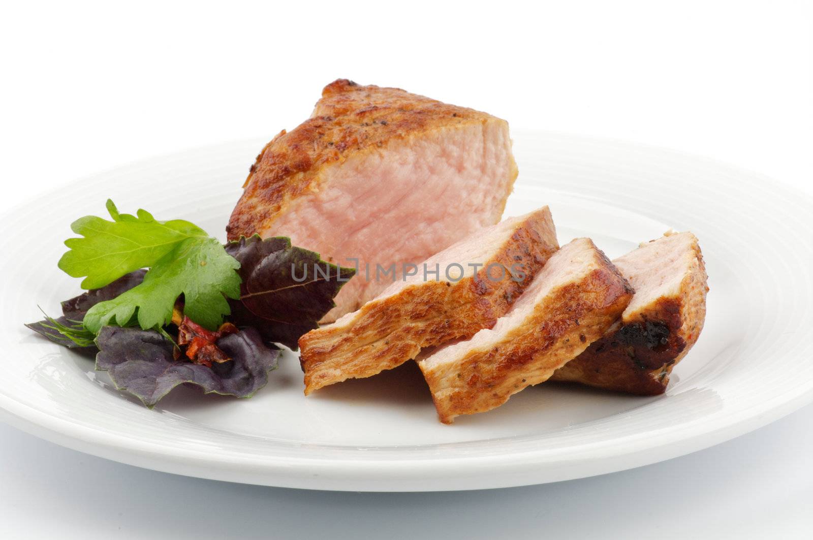 Spicy roast pork with basil and pasley closeup on white background