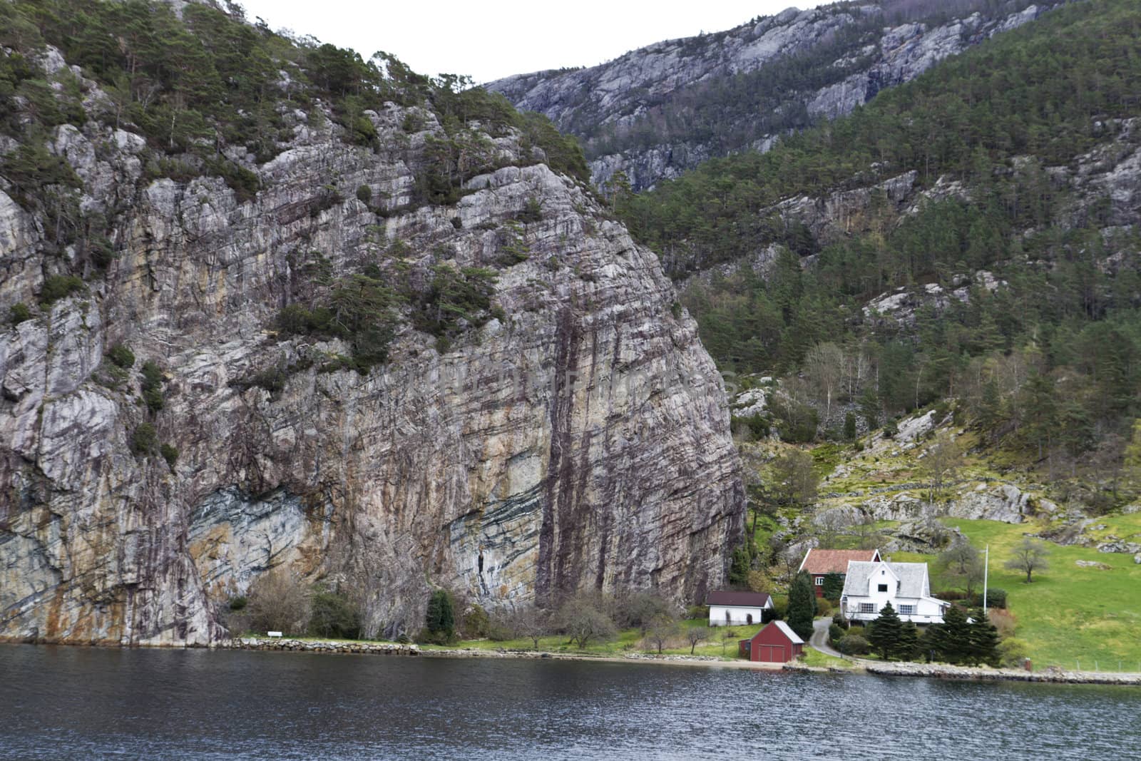 some houses under big rock at coastline in norway