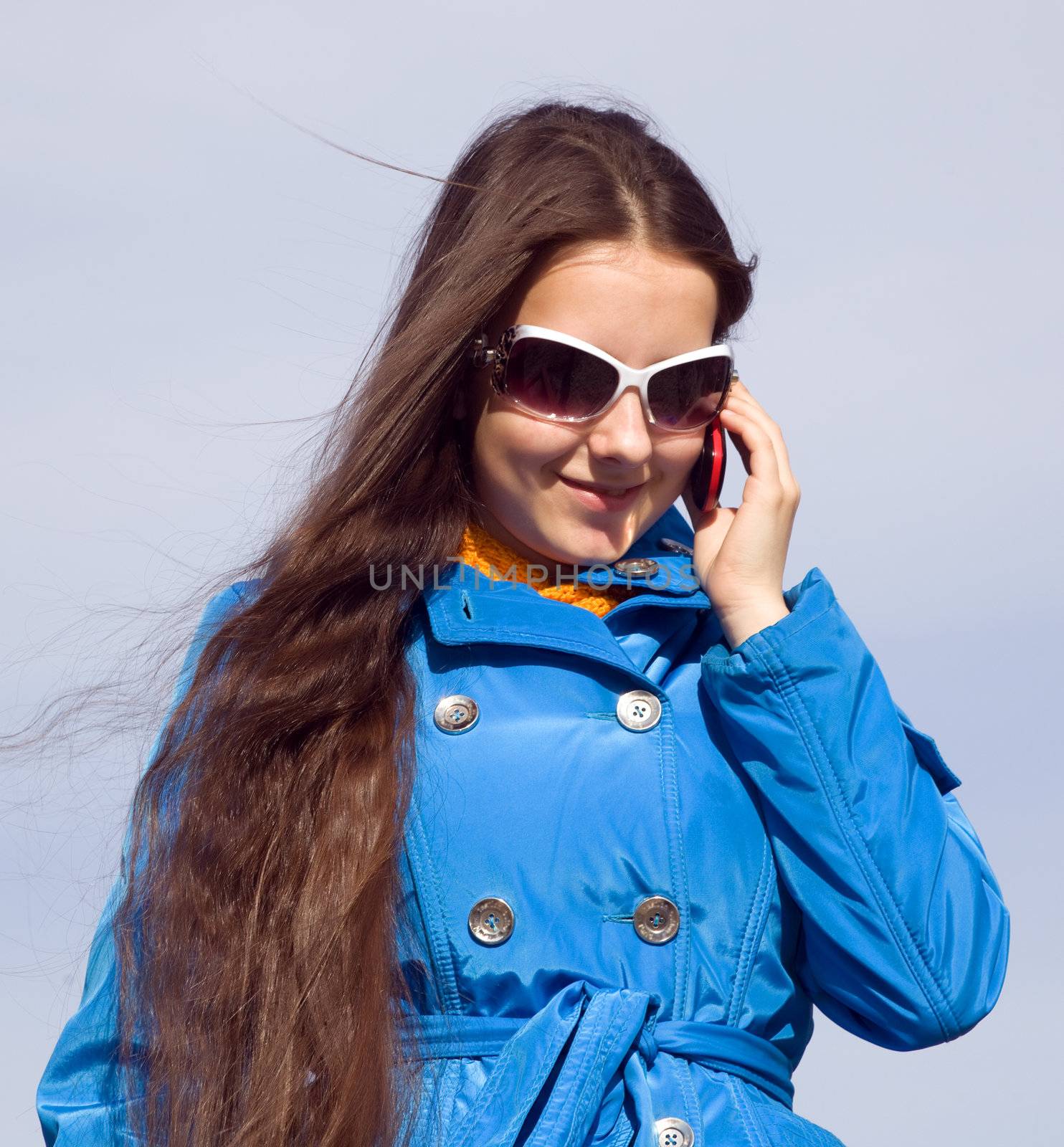 A girl in dark glasses talking on cell phone by AleksandrN