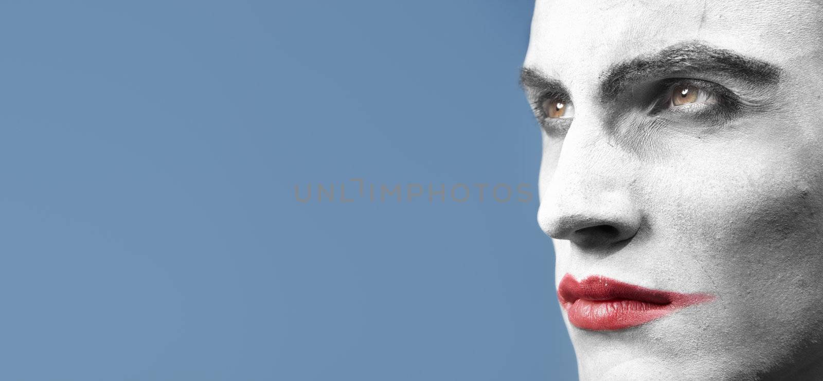 Face-painted man outdoors. Horizontal close-up photo with empty space