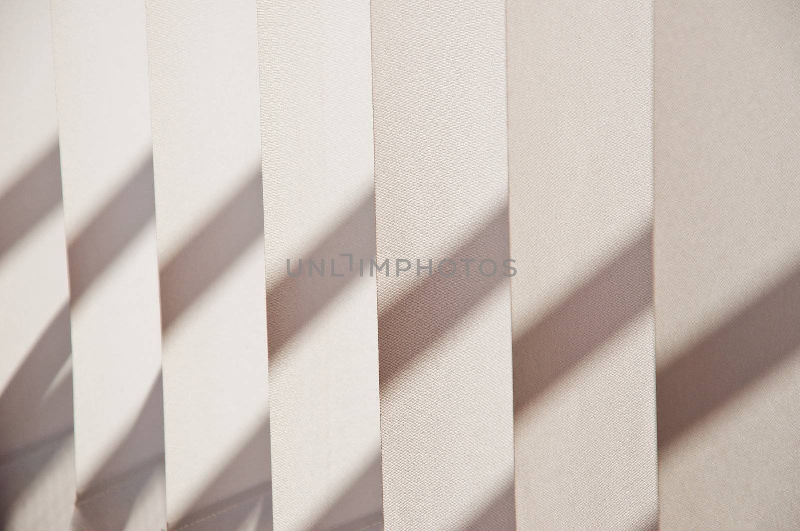 Fragment of blinds a beige fabric with shadow close up