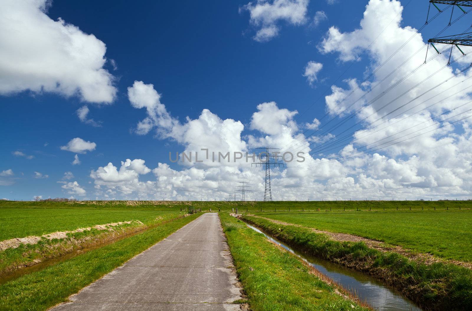 road for bicycles through green pastures and with beautiful sky