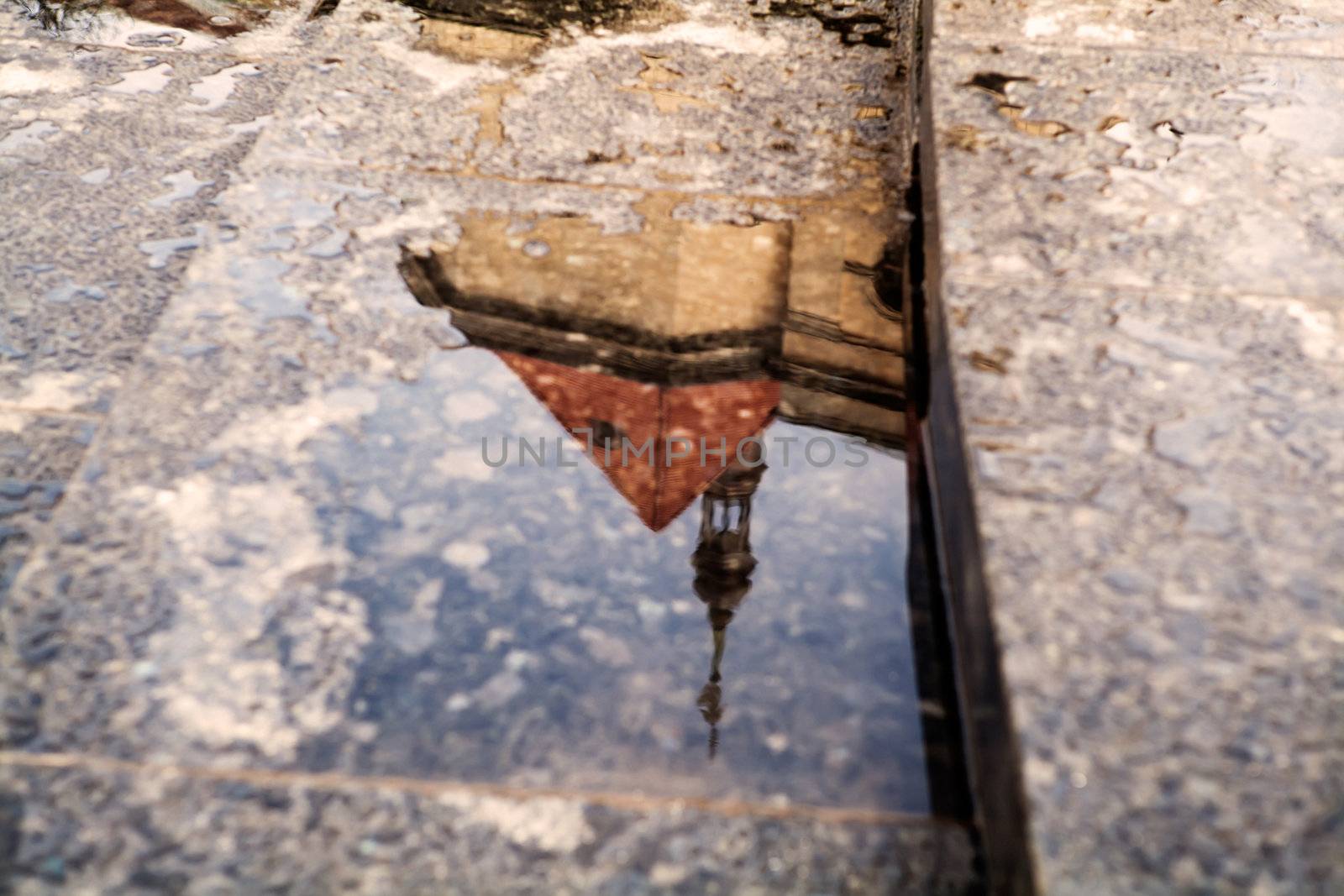 reflection of building in puddle in Lviv after rain