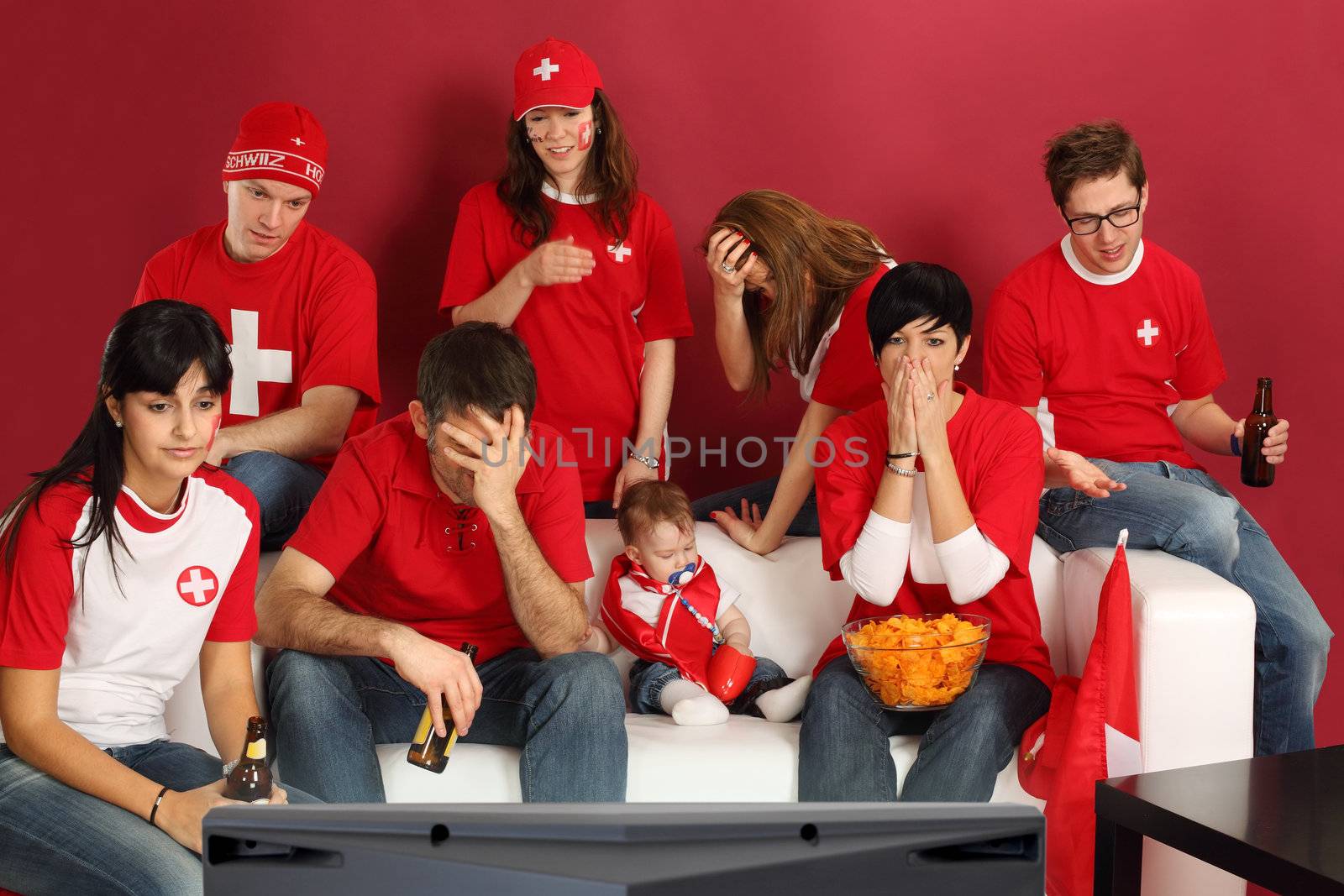 Photo of Swiss sports fans watching television and being disappointed with the game.