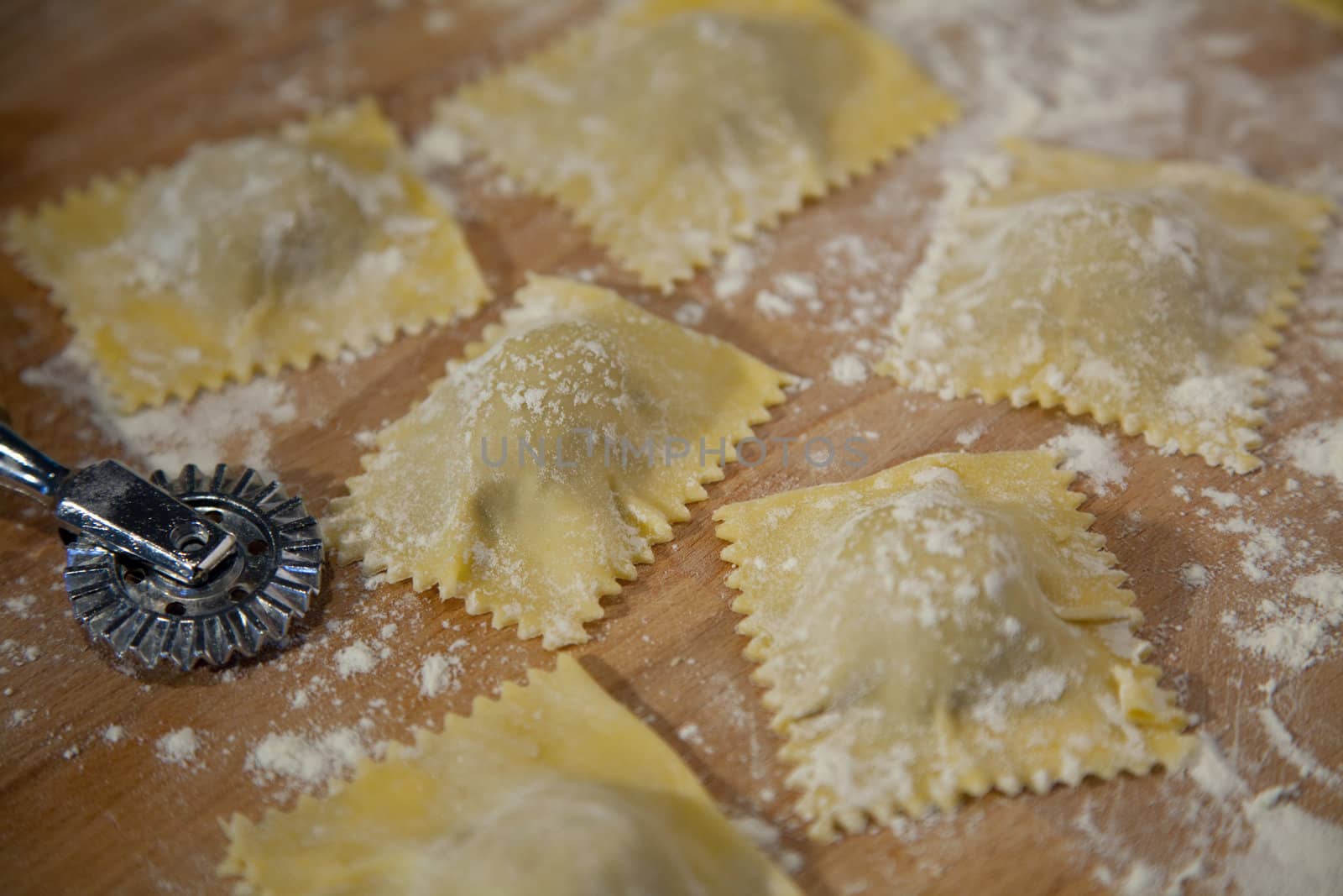 Preparation of homemade Ravioli with veal stuffing on wooden plate - shallow depth of field
