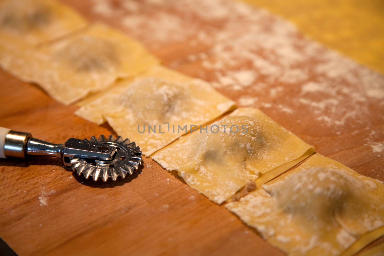 Preparation of homemade Ravioli with veal filling on wooden plate - shallow depth of field