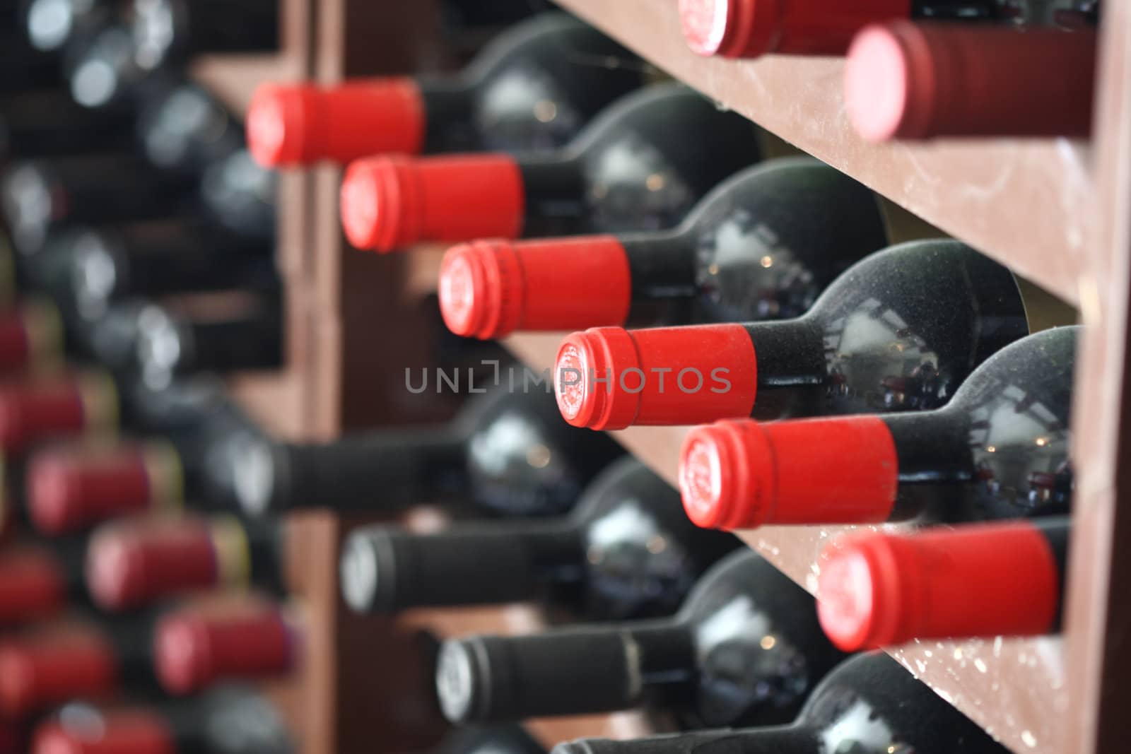 Redwine bottles with red caps in a cellar