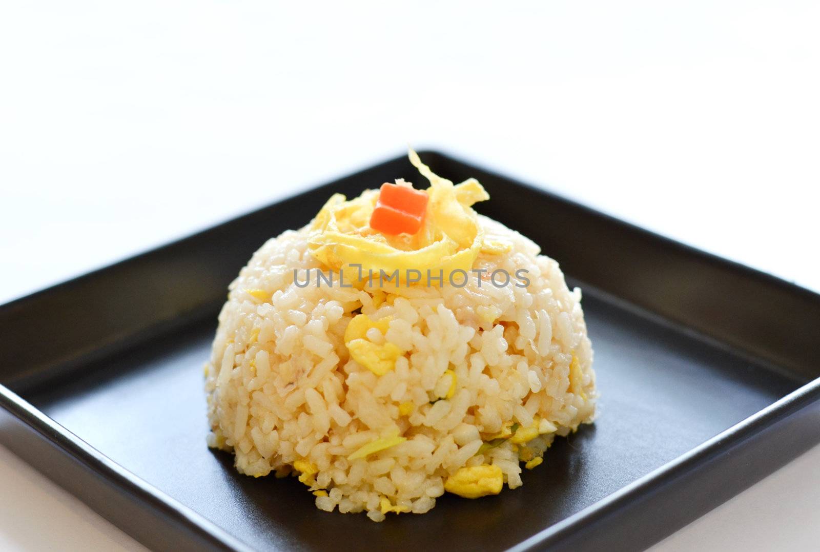  fried rice served with slice the omelet on black plate