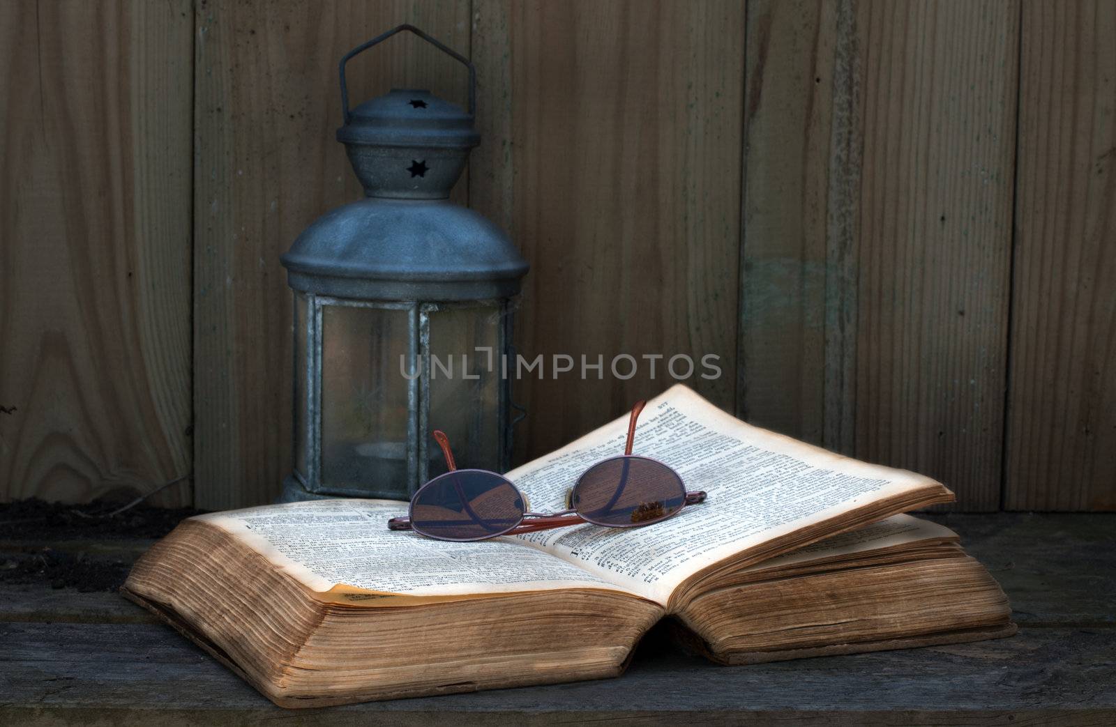 old bible still life with light and glasses