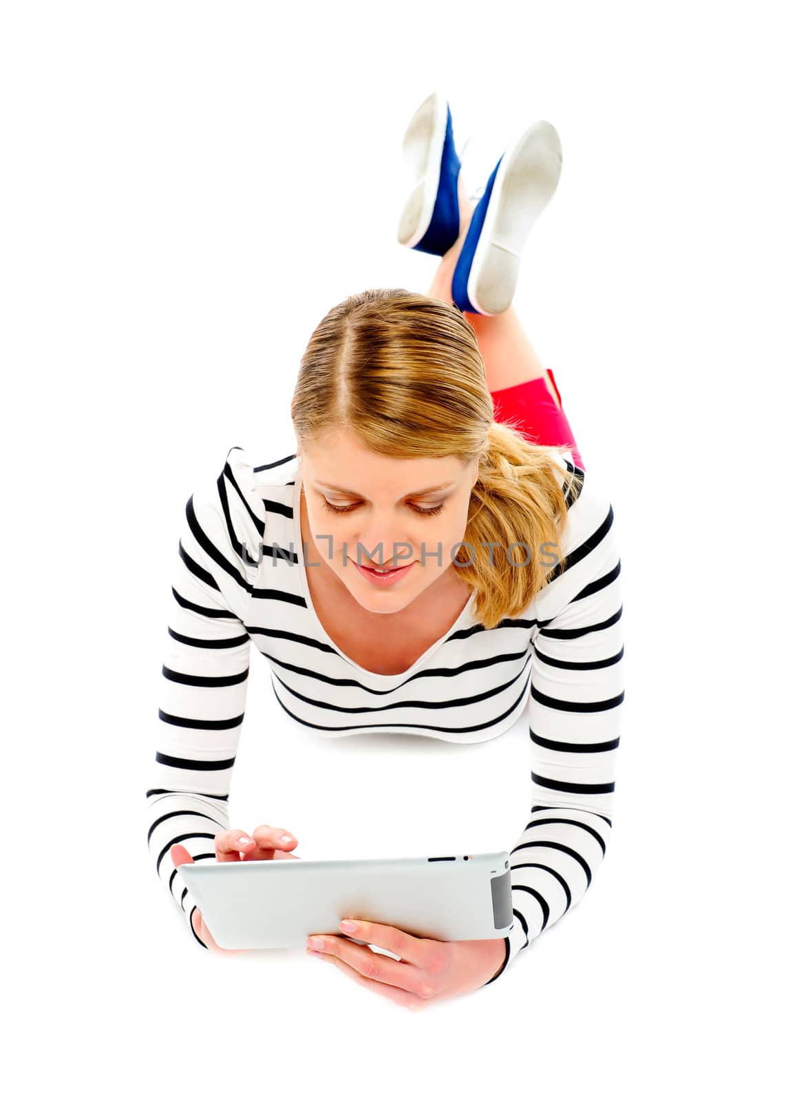 Woman using tablet computer. Lying on floor, white background