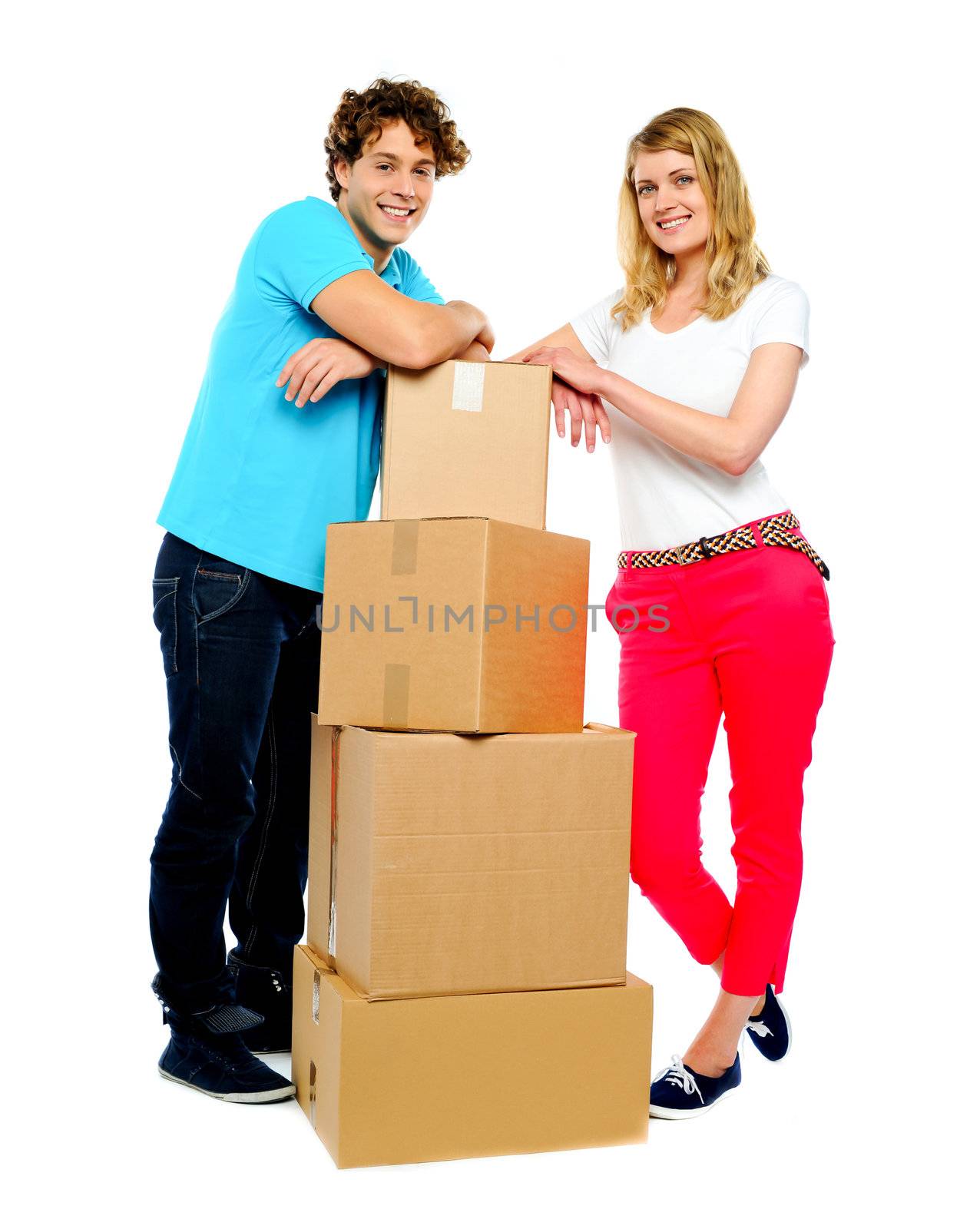 Teenager couple posing beside cardboard boxes. Full-length shot