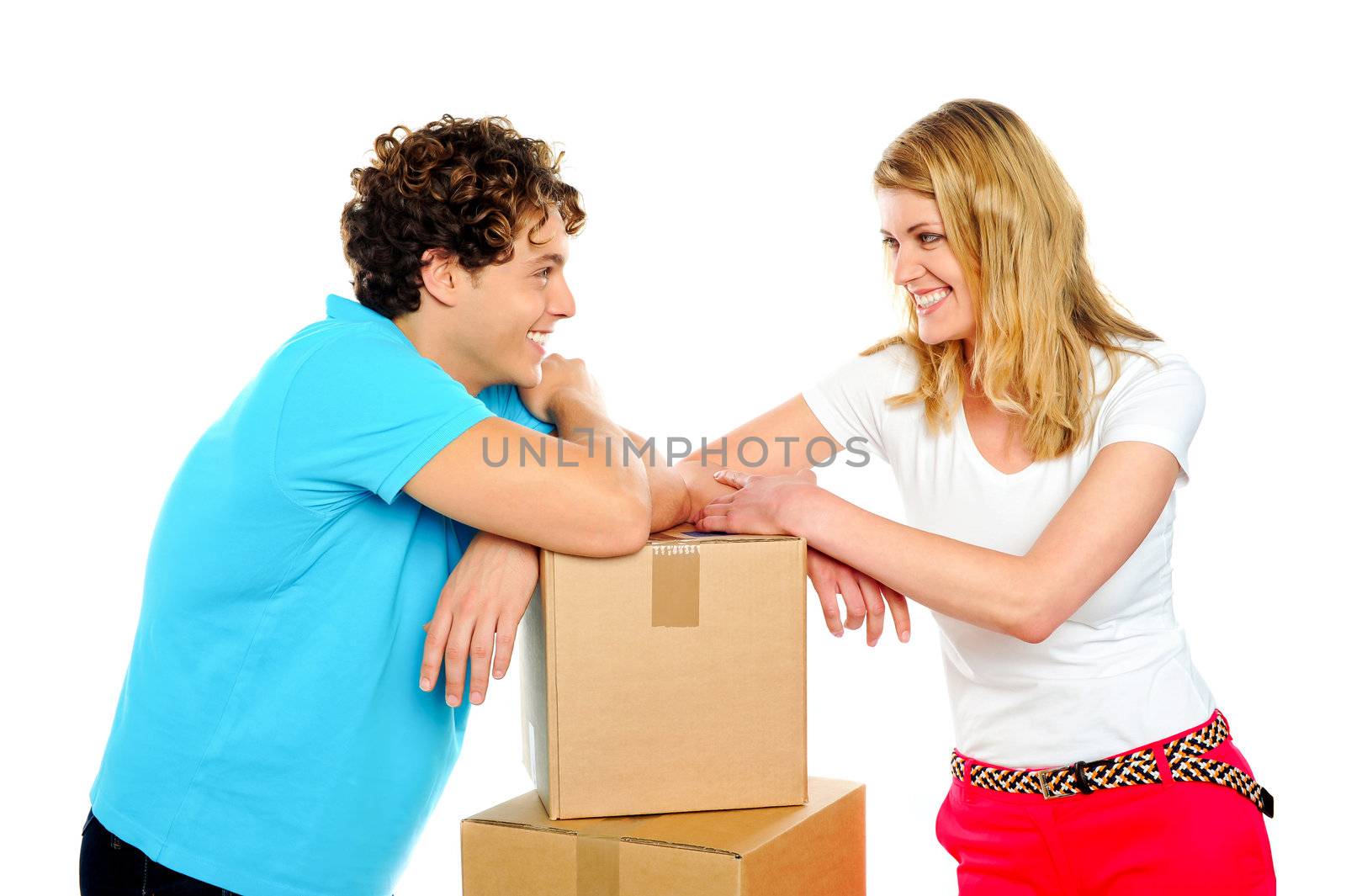 Lovable young smiling couple with boxes looking into each others eyes. Love concept