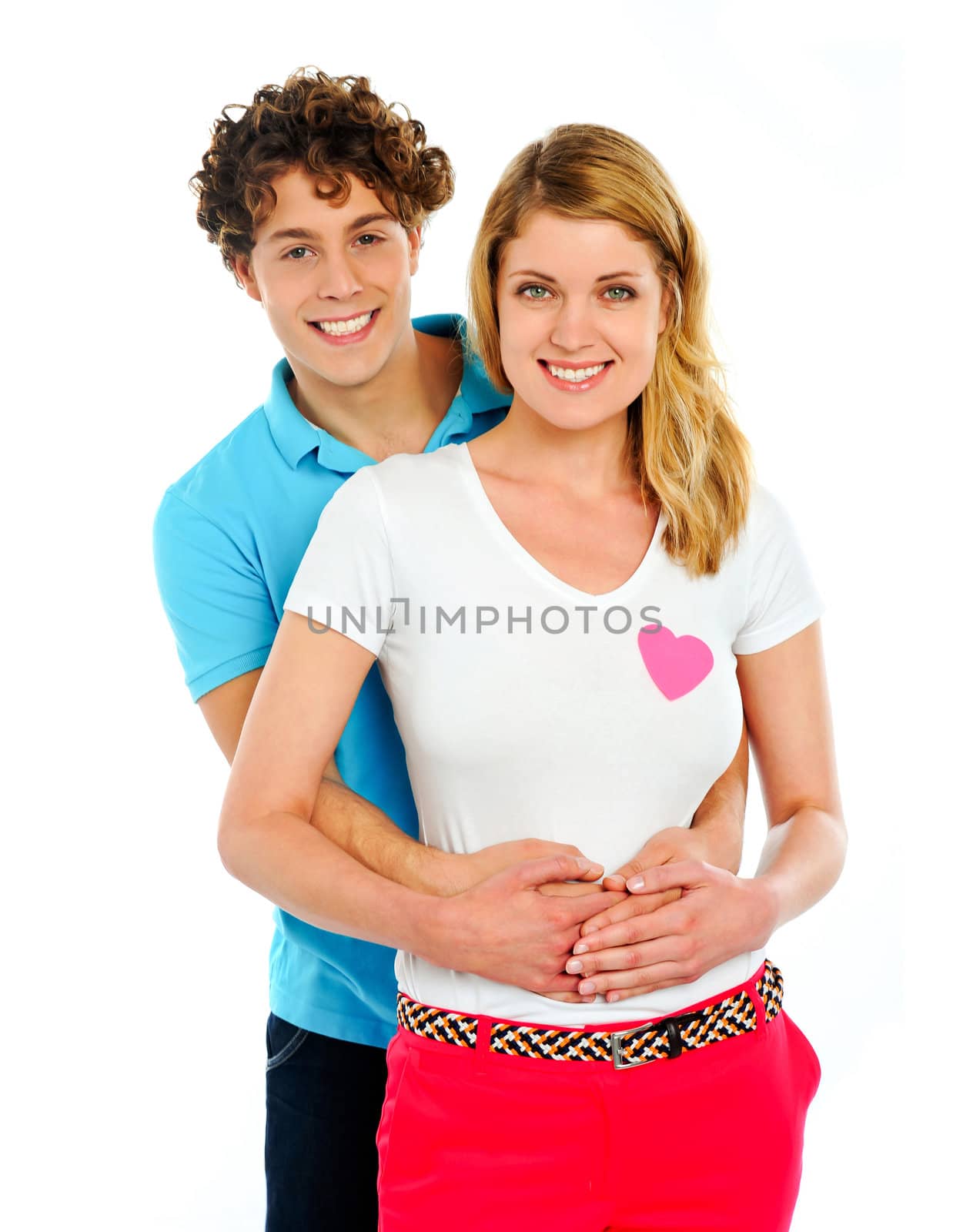 Smiling young couple standing together, posing in studio