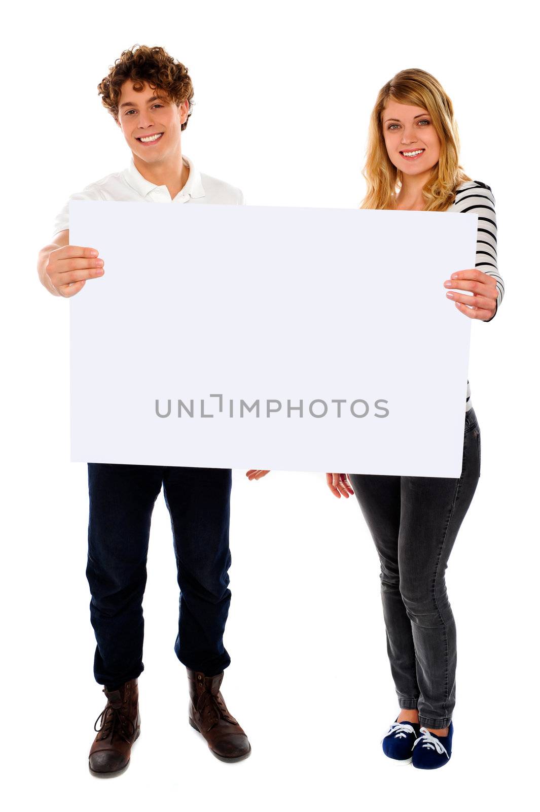 Adorable young couple promoting blank banner ad isolated over white