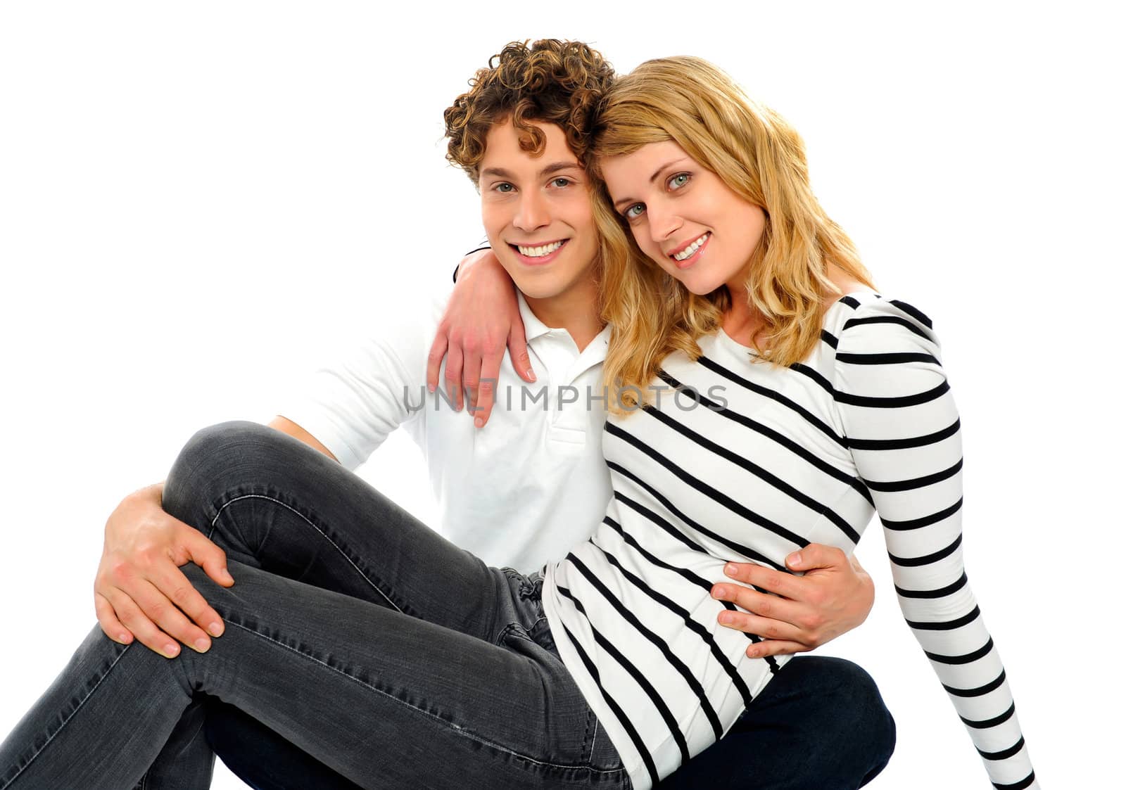 Female friend sitting on her boyfriends lap. Smiling at camera. Boyfriend holding