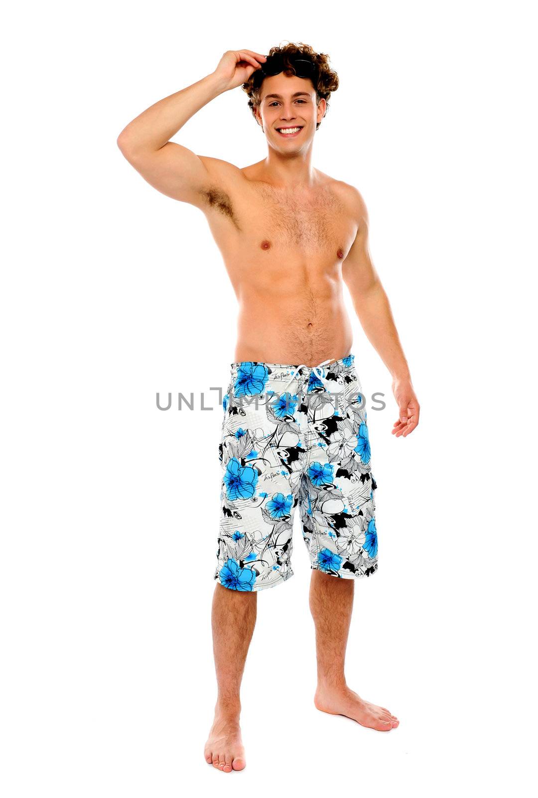 Shirtless muscular guy in swimming costume isolated against white background