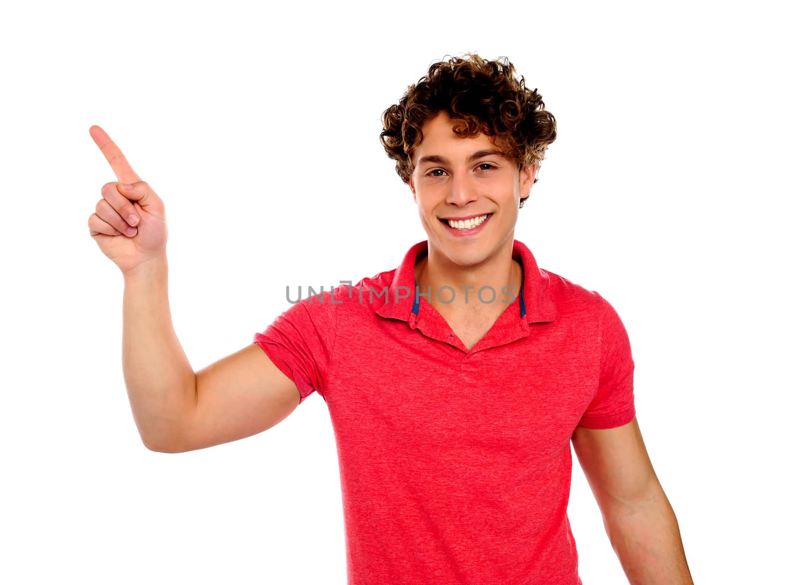 Handsome young teenager in casuals pointing away isolated over white