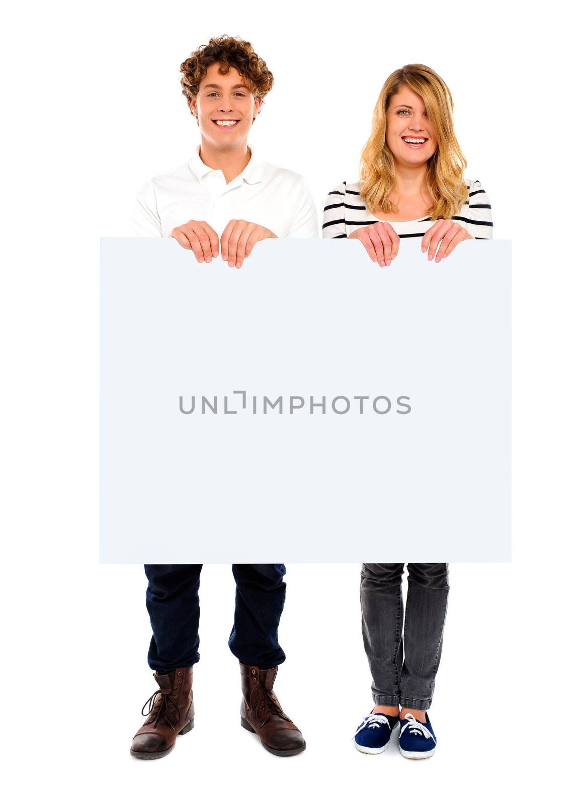 Young couple standing with white board and smiling at camera