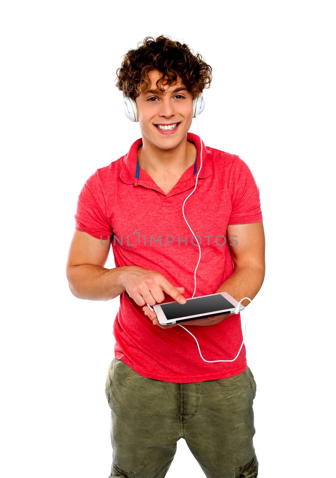 Guy enjoying music having headphones attached to tablet