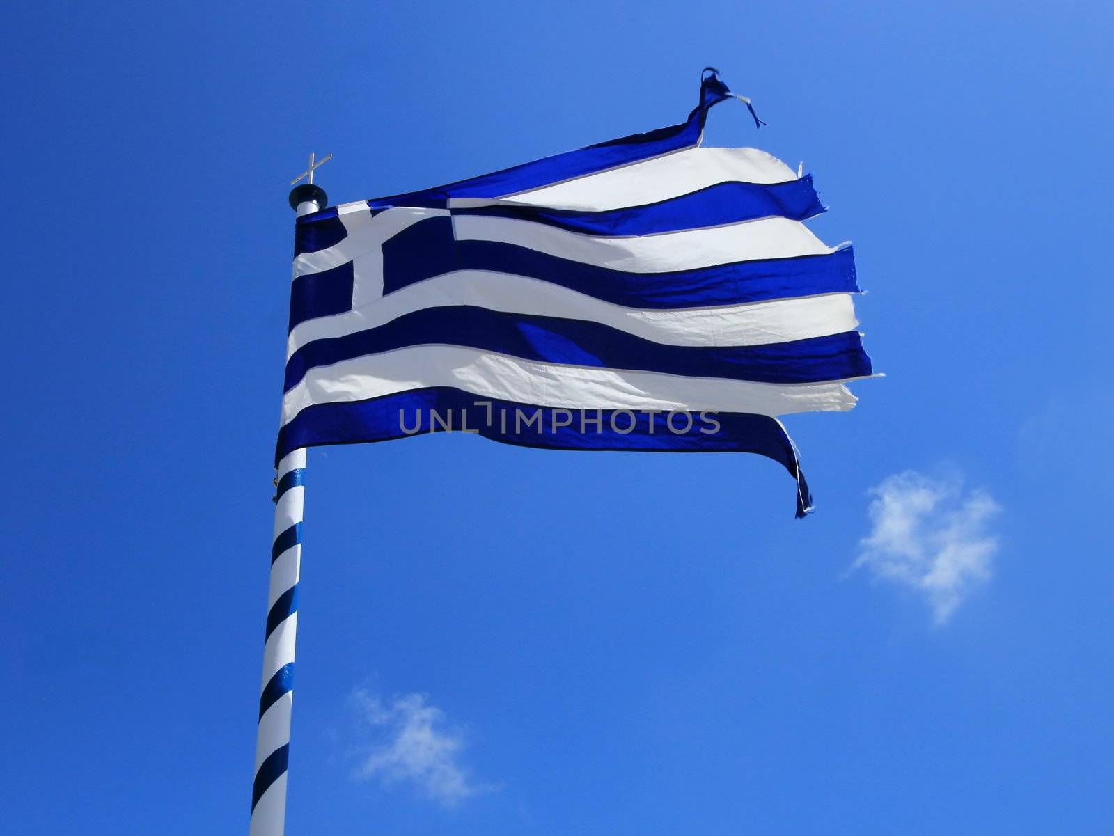 Used greek flag teared up and blue sky with little cloud background