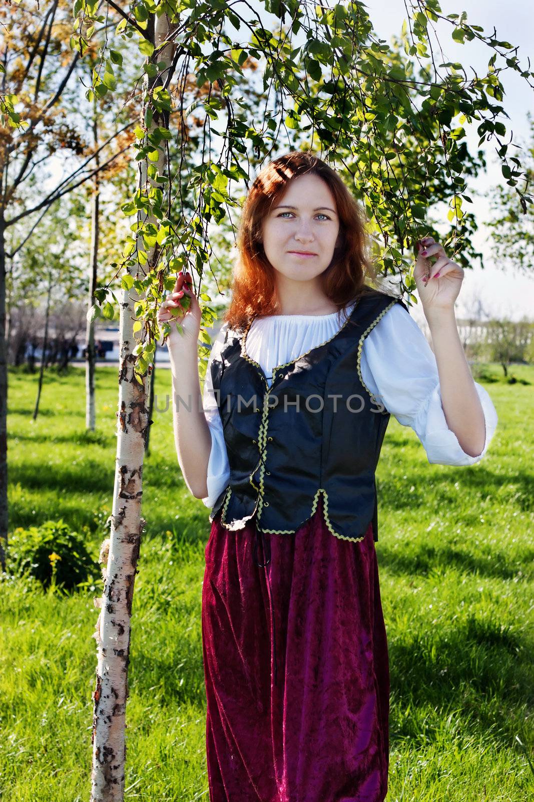 Medieval woman standing near the birch