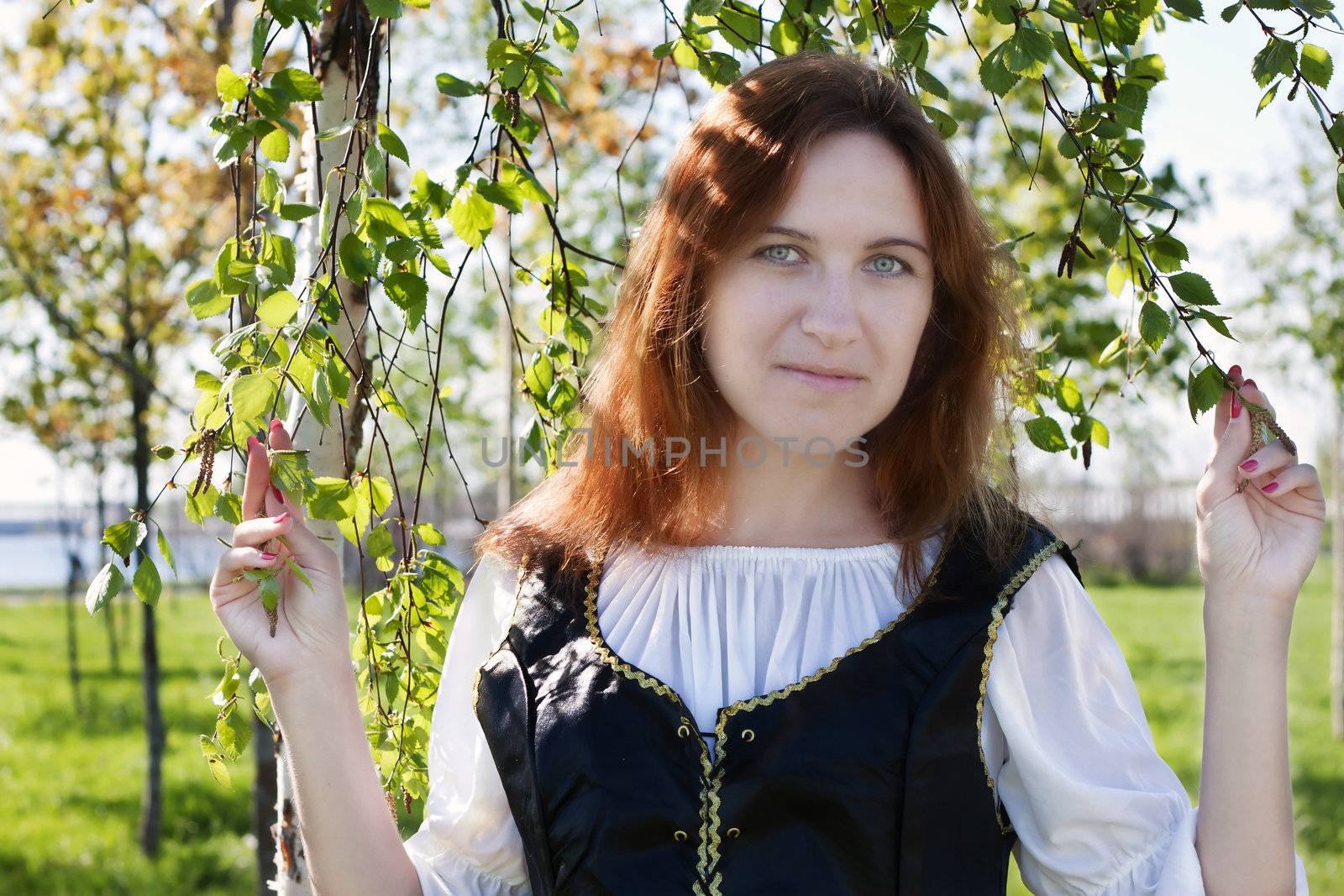 Medieval woman standing near the birch