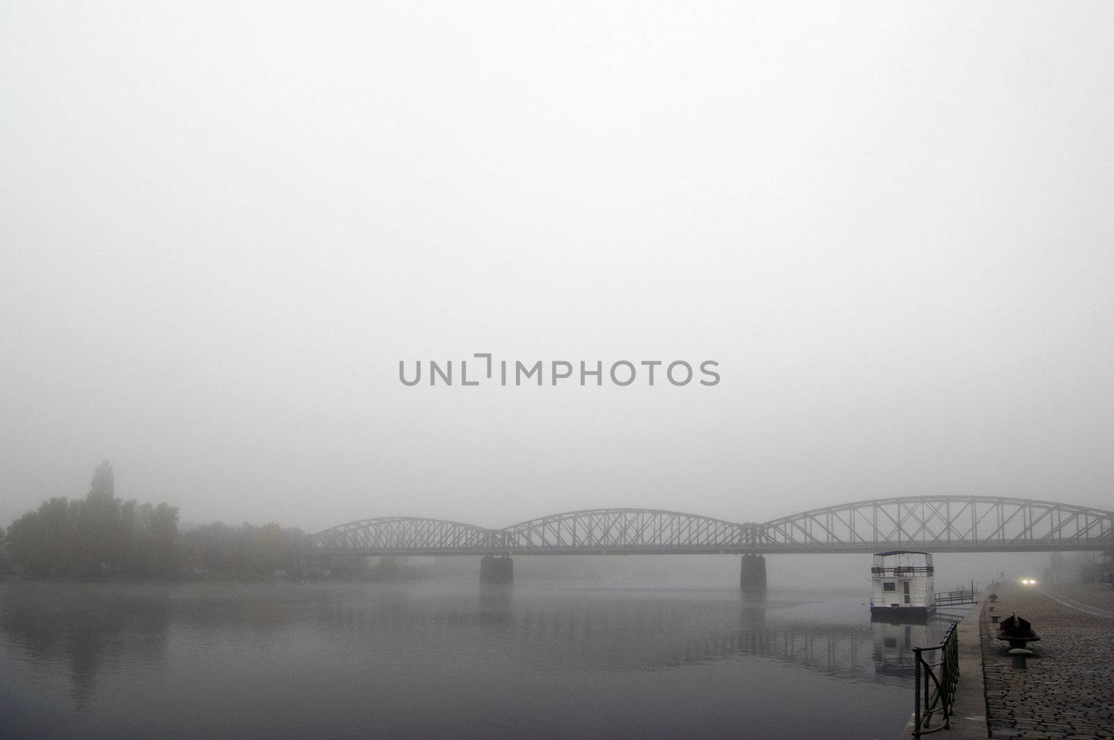 Prague railway bridge in early morning fog