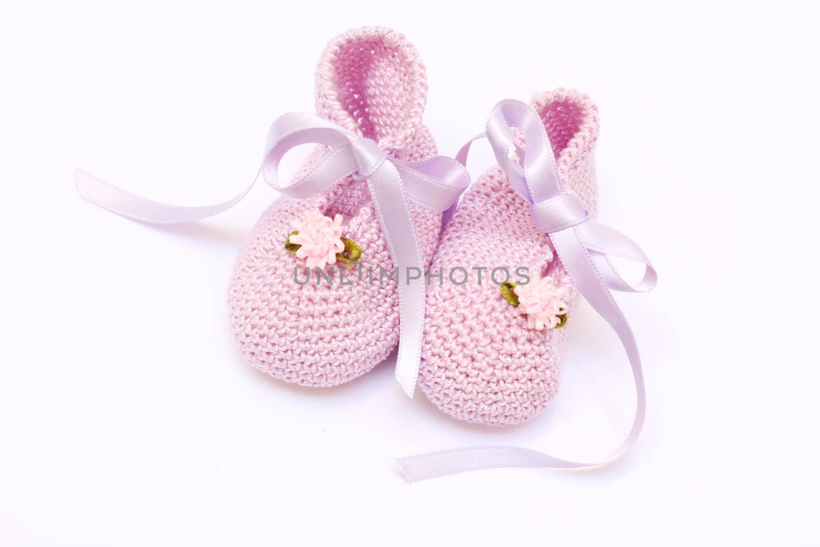 baby pink knitted booties isolated on white